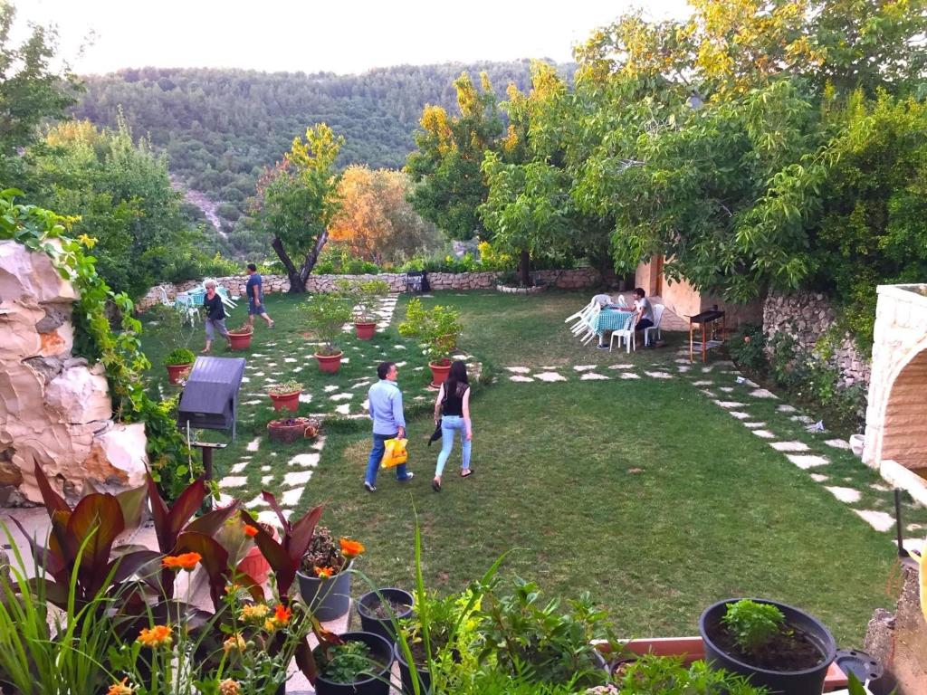 um grupo de pessoas caminhando em um jardim em El Achkar Guesthouse em Beït ed Dine