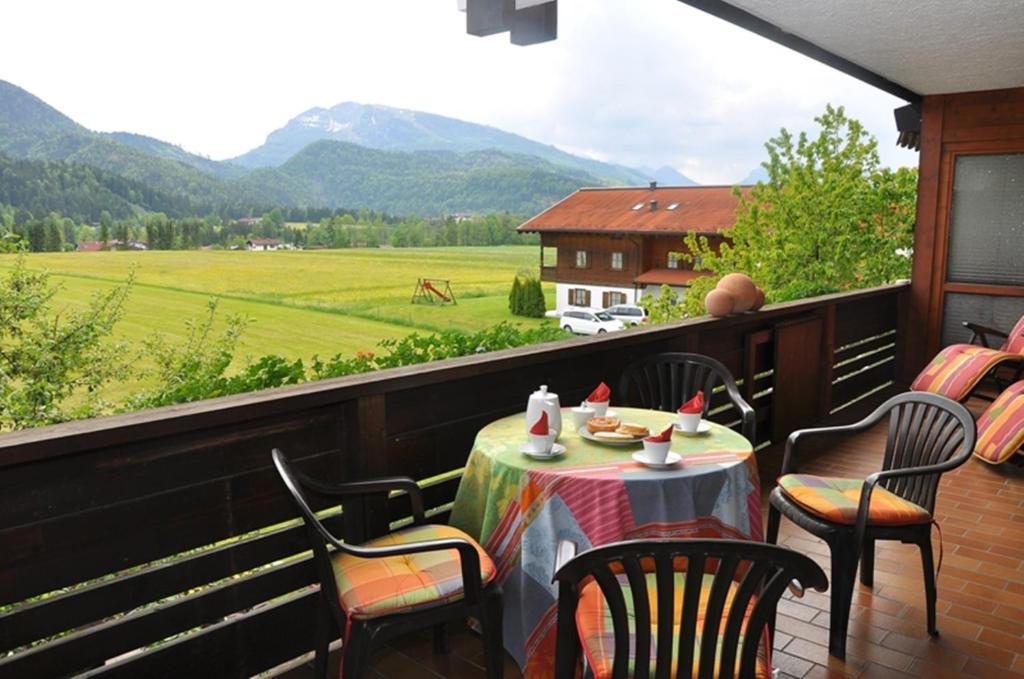 einen Tisch auf einem Balkon mit Blick auf ein Feld in der Unterkunft Alpenglühn in Reit im Winkl