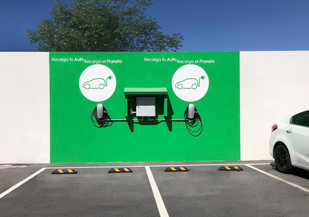 a large green sign in a parking lot at Ramada Encore by Wyndham Guadalajara Aeropuerto in Guadalajara