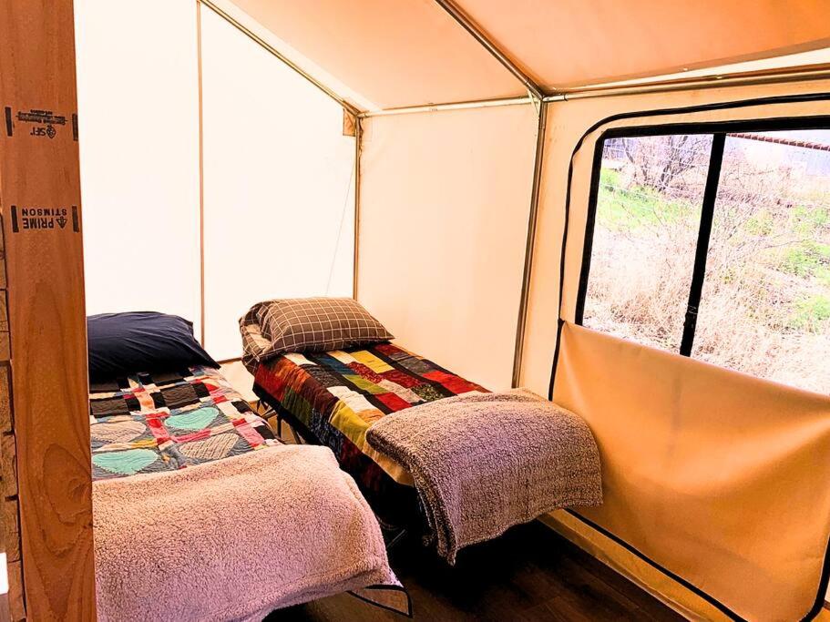 a room with two beds in the back of a tent at Silver Spur Homestead Luxury Glamping - The Cowboy in Tombstone