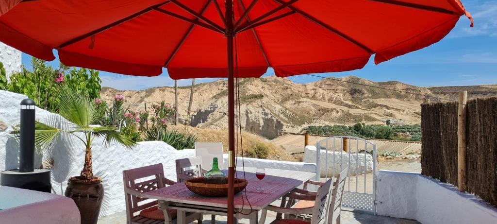 un paraguas rojo sentado sobre una mesa en Cuevas Los Coloraos - El Bandido, en Villanueva de las Torres