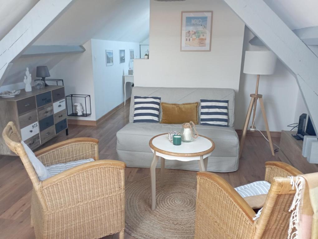 a living room with a couch and chairs and a table at Charmant cocon à Malo-les-bains in Dunkerque