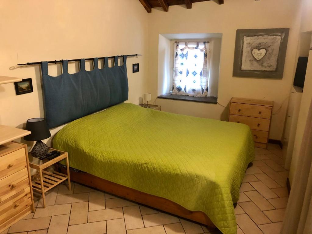 Un dormitorio con una cama verde y una ventana en VITERBO ART APARTMENTS en Viterbo