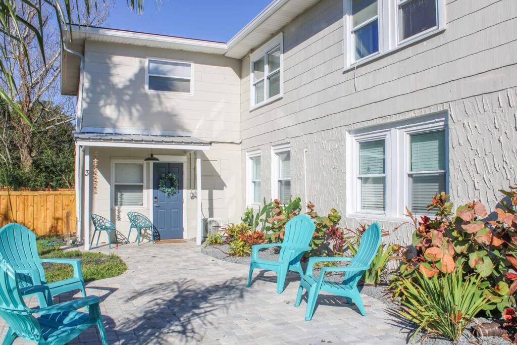 a patio with blue chairs in front of a house at Beachside Retreat Awaits at Jacksonville Beach in Jacksonville Beach