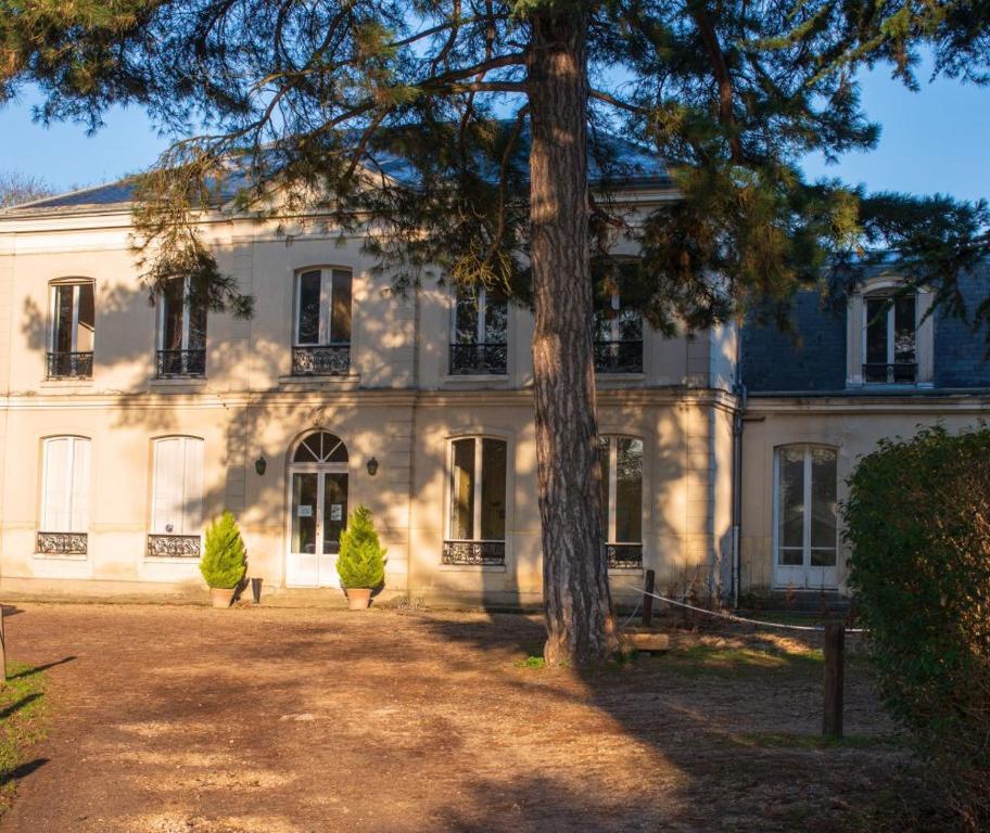 uma grande casa branca com uma árvore em frente em Tiers lieu de l'Ermitage em Versalhes