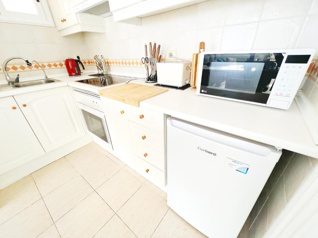 a white kitchen with a microwave and a dishwasher at !!! Relaxing View, The Heights Apartment With Terrace and Heated Pools, Los Cristianos in Los Cristianos