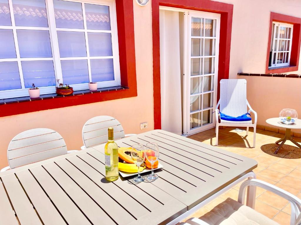 a table with a bottle of wine and glasses on it at !!! Relaxing View, The Heights Apartment With Terrace and Heated Pools, Los Cristianos in Los Cristianos