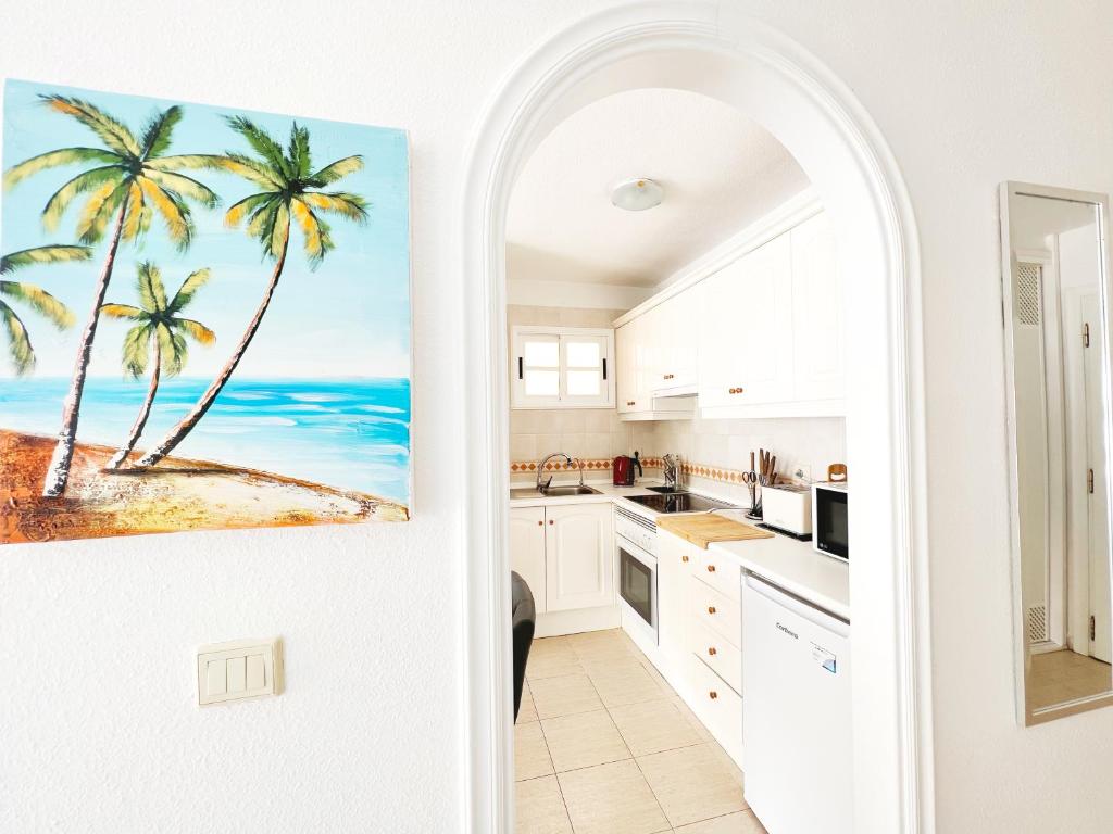 a kitchen with a painting of palm trees at !!! Relaxing View, The Heights Apartment With Terrace and Heated Pools, Los Cristianos in Los Cristianos