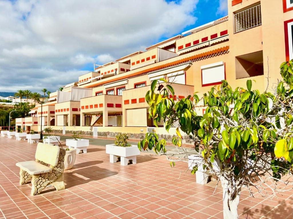 a building with a row of benches in front of it at !!! Relaxing View, The Heights Apartment With Terrace and Heated Pools, Los Cristianos in Los Cristianos