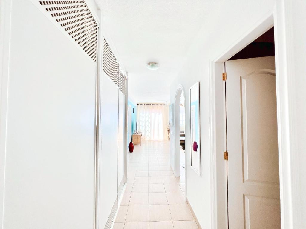 a hallway of a house with white walls and white floors at !!! Relaxing View, The Heights Apartment With Terrace and Heated Pools, Los Cristianos in Los Cristianos