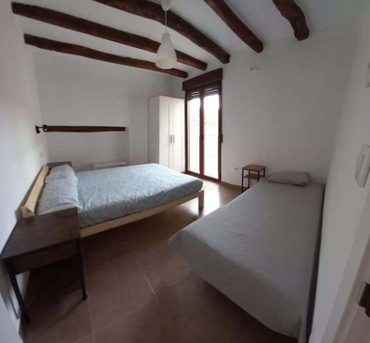 a bedroom with two beds and a large window at Casa rural La Azuleja de Alatoz in Alatoz