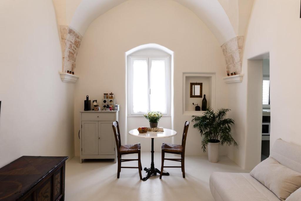 uma sala de estar com mesa e cadeiras em moma Ostuni Boutique Home em Ostuni