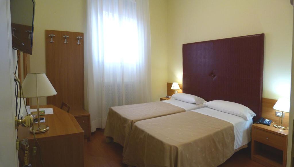 Postel nebo postele na pokoji v ubytování Hotel Centrale Byron