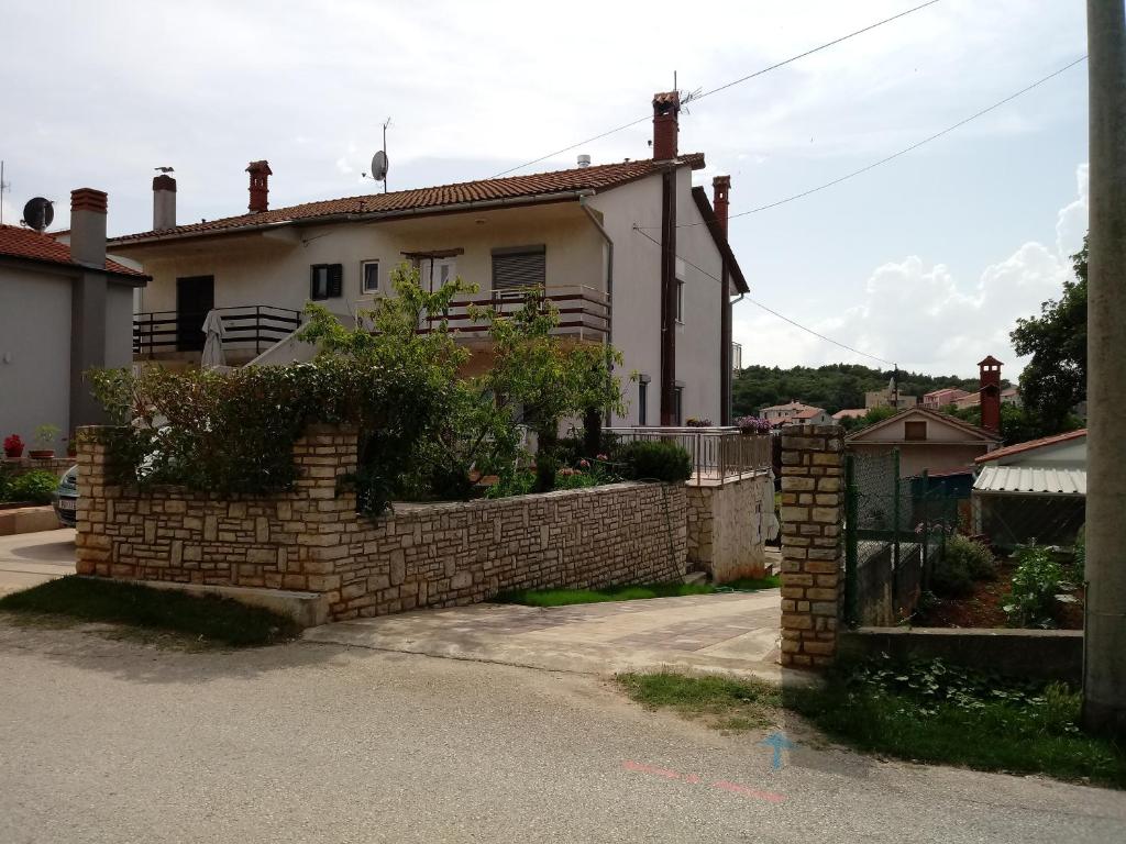 a brick fence in front of a house at Apartment Violeta in Pula