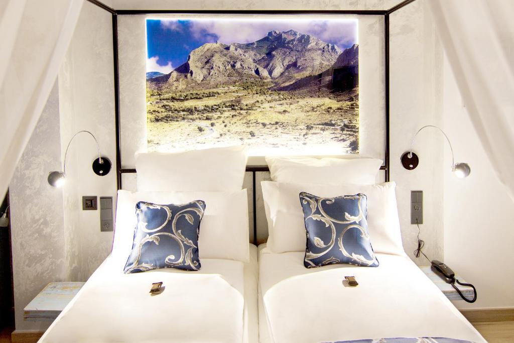 een slaapkamer met 2 bedden en een schilderij aan de muur bij Boutique Hotel Sierra de Alicante in Busot