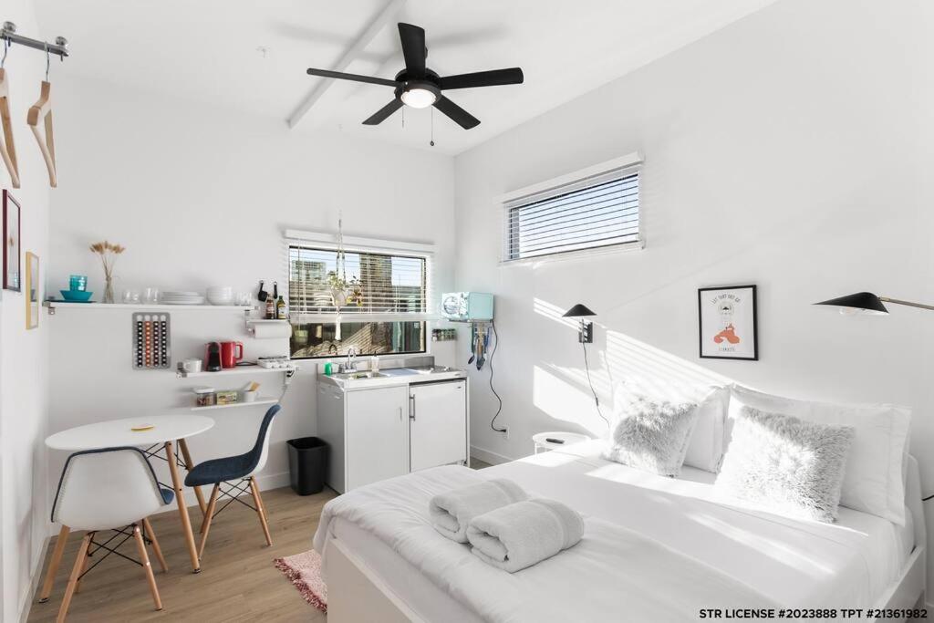 斯科茨Micro Studio with balcony & pool view - Walk to OT的一间带床和桌子的白色卧室