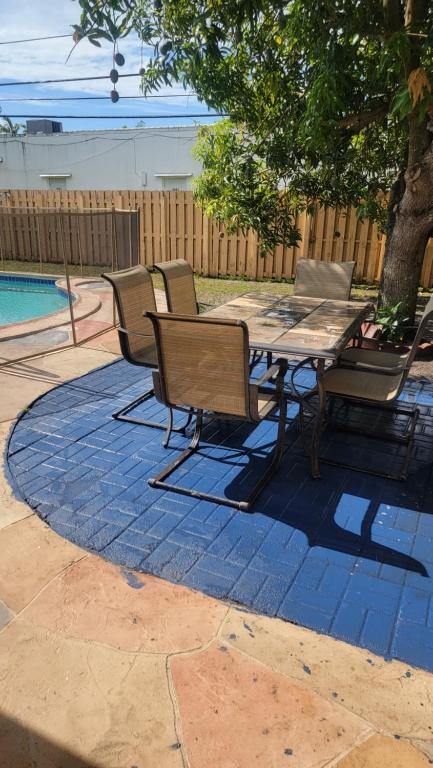 a patio with a table and chairs next to a pool at Tiny Efficiency All-In-1 in Sunrise