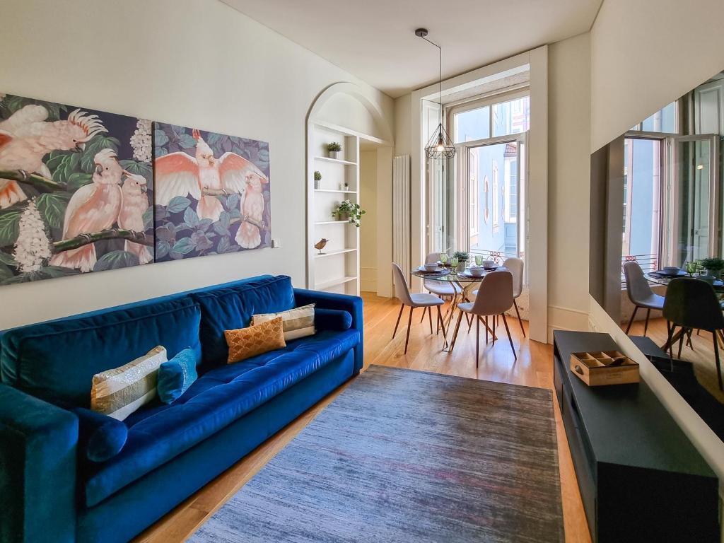 - un salon avec un canapé bleu et une table dans l'établissement Inspiring City Center 1BR Apartment, à Porto