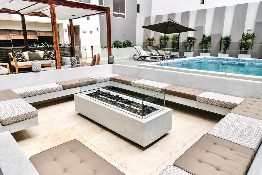 a hotel lobby with a pool and a table and chairs at Martinto by Wynwood House in Lima