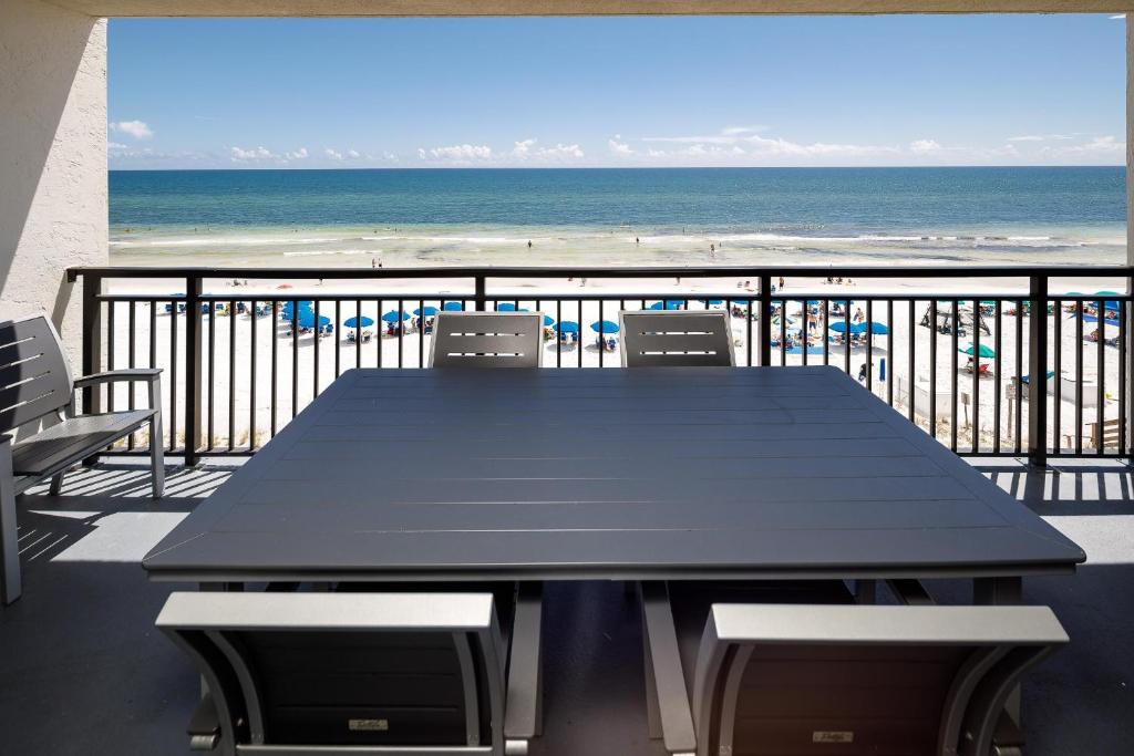 沃爾頓堡灘的住宿－Nautilus 1503 - Gulf Front 2 Bedroom 5th Floor，海滩阳台的一张黑桌子和椅子