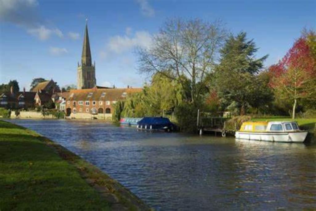 a boat on a river with a church in the background at 1 bedroom flat sleeps 4 in Abingdon Oxfordshire in Abingdon
