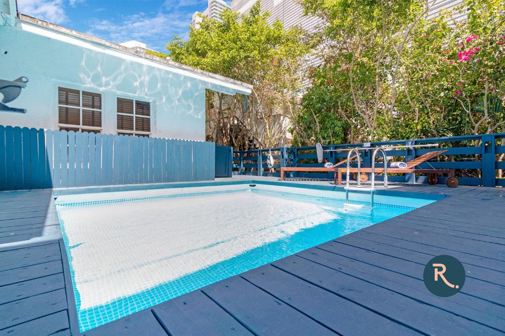 a swimming pool on a deck next to a house at Roami at Villa Bella in Miami
