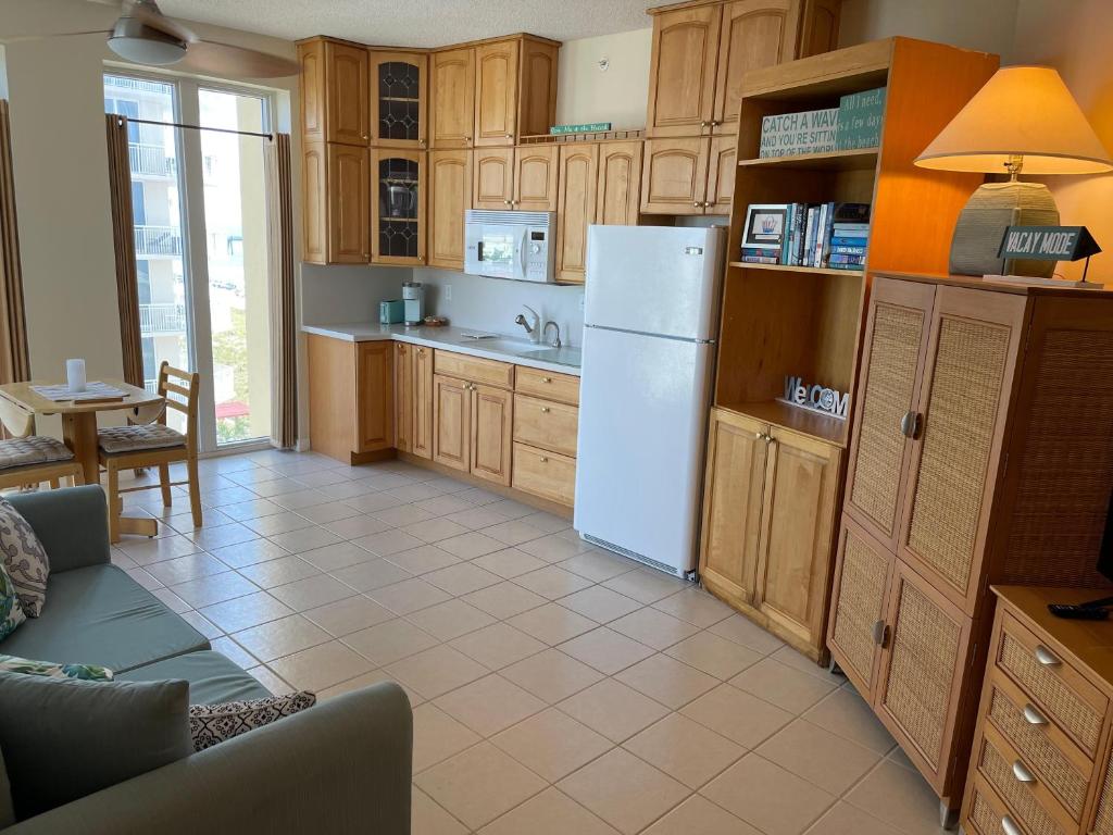 a kitchen with a white refrigerator and wooden cabinets at Caribbean Resort 501A - Link To The Beach in Navarre