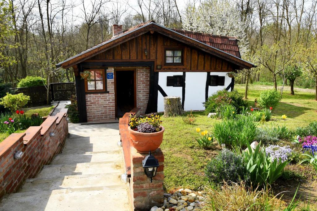 a small house with a flower garden in front of it at Kuća za odmor Kristina in Novigrad Podravski