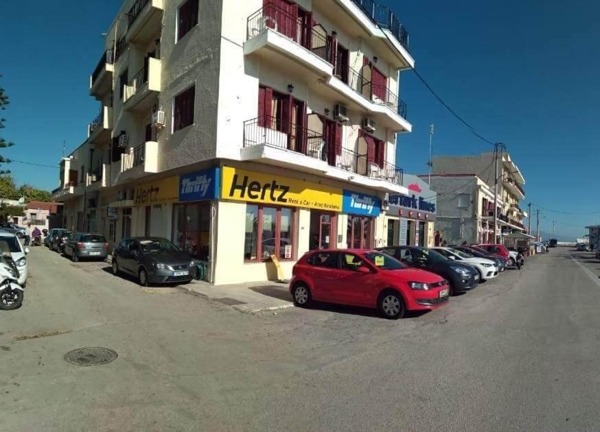 un coche rojo estacionado frente a un edificio en Omiros rooms en Chios