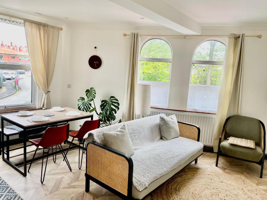 a living room with a couch and a table and chairs at The Old Dance School - 1 and 2 Bedroom Apartments in the Heart of Chesterfield in Chesterfield