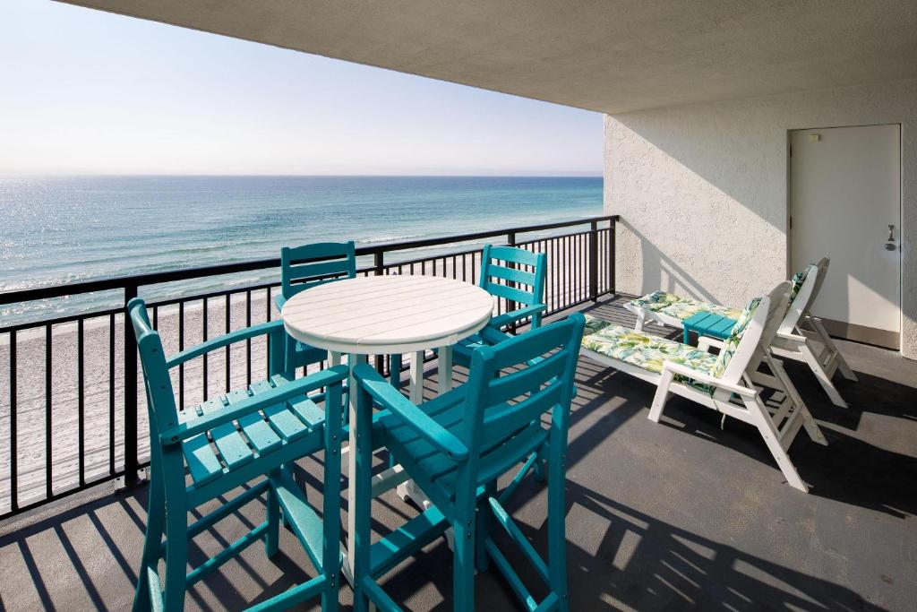 einen Tisch und Stühle auf einem Balkon mit Meerblick in der Unterkunft Nautilus 1604 - Gulf Front 2 Bedroom - 6th Floor in Fort Walton Beach