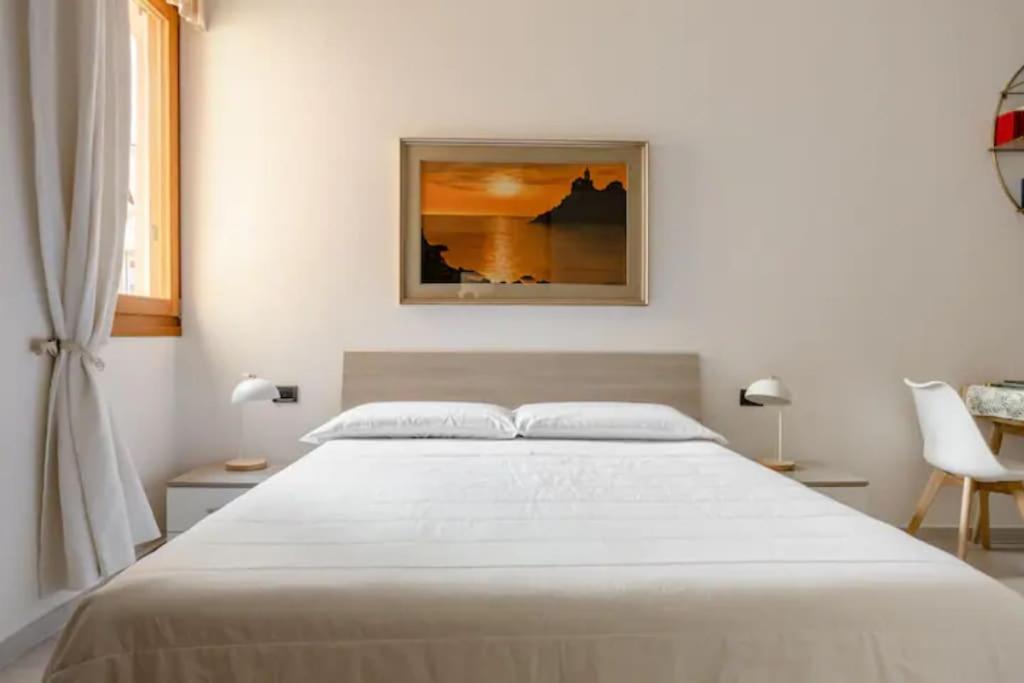 - une chambre dotée d'un grand lit blanc avec une photo sur le mur dans l'établissement Appartamento il Mugnaio, à Bologne