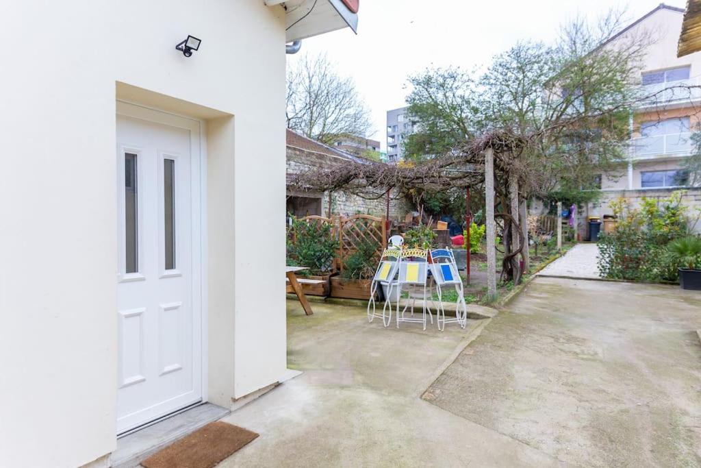 een witte deur en een patio met een tafel en stoelen bij L'élégante maisonnette - T2 - paris - Orly - RER C in Vitry-sur-Seine