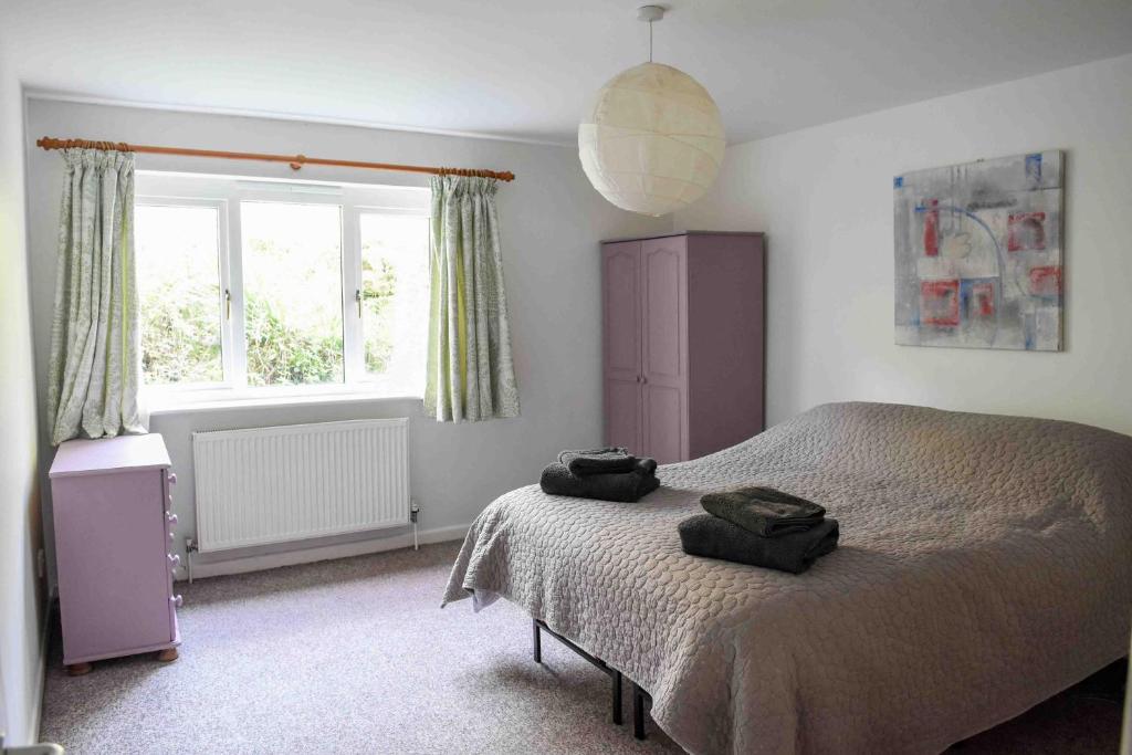 a bedroom with a bed with two bags on it at Badgers Holt House in Plymouth