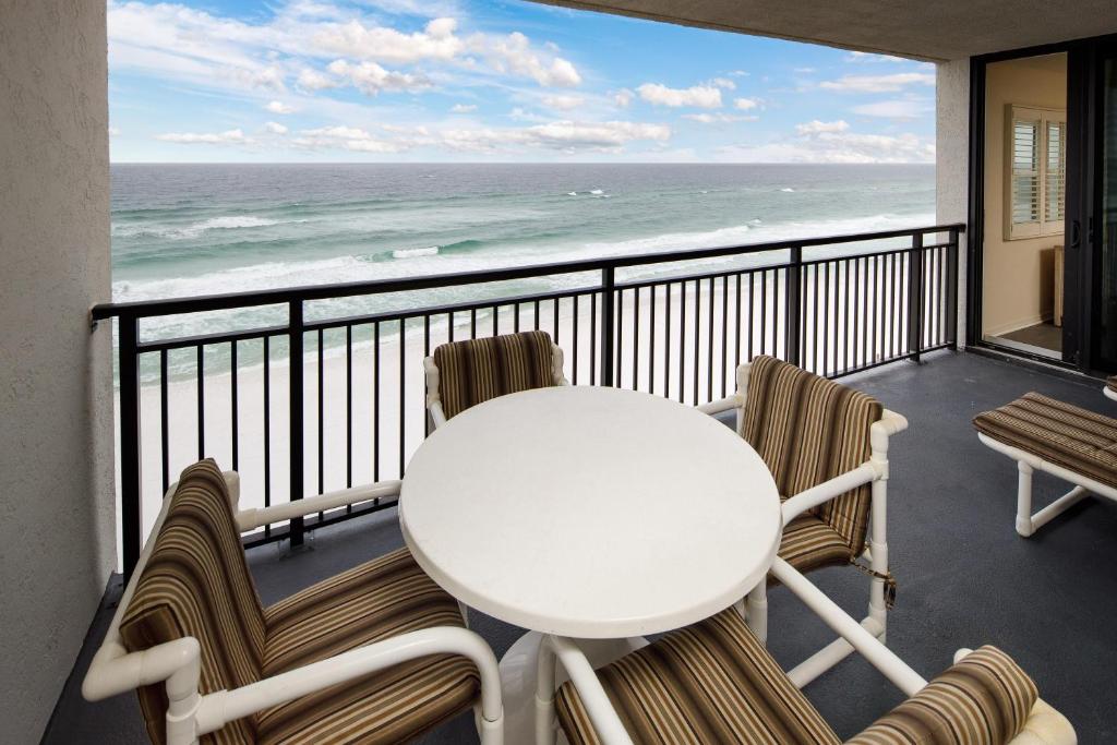 フォート・ウォルトン・ビーチにあるNautilus 1702 Gulf Front Large 2 Bedroom Penthouse 7th Floorの白いテーブルと椅子、海を望むバルコニー