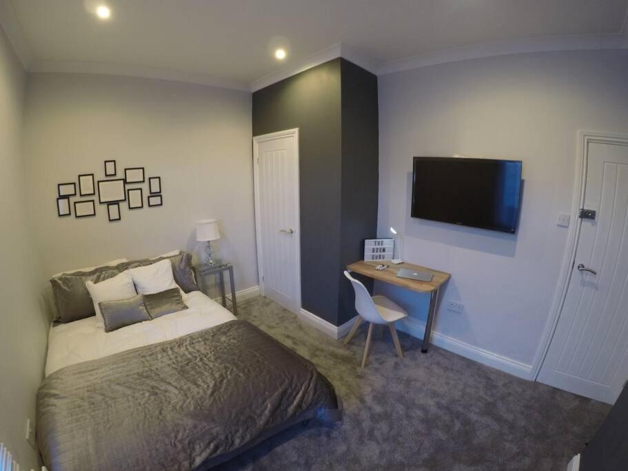 En eller flere senge i et værelse på Essex House 3 Bedrooms Workstays UK