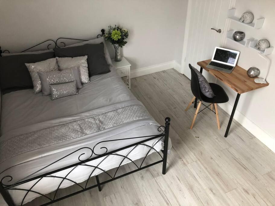 a bedroom with a bed and a desk with a laptop at Falmouth House 3 Bedrooms 5 Beds Workstays UK in Middlesbrough