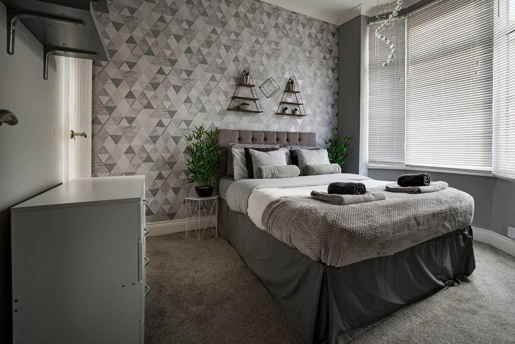 a bedroom with a large bed with towels on it at Haddon House Workstays UK in Middlesbrough