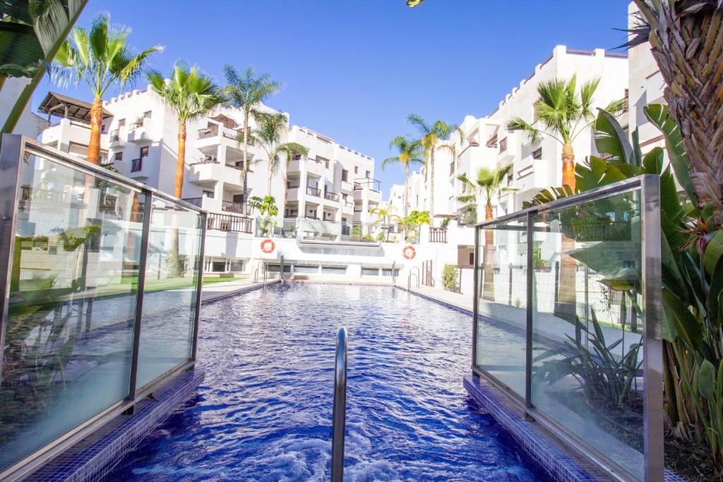 una piscina en medio de un edificio con palmeras en RentitSpain El Oasis de Salobreña en Salobreña