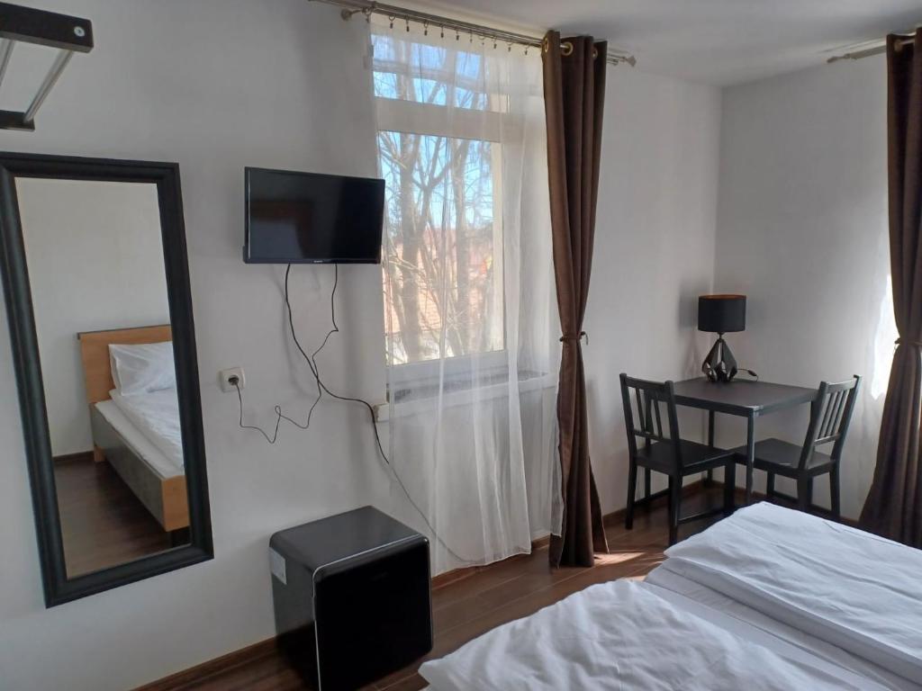 1 dormitorio con cama, espejo y mesa en Vila Oltețul, en Predeal