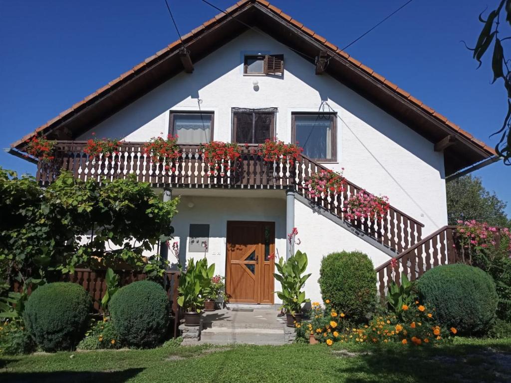 Casa blanca con balcón con flores en Apartman PLUM PLITVICE en Drežnik Grad