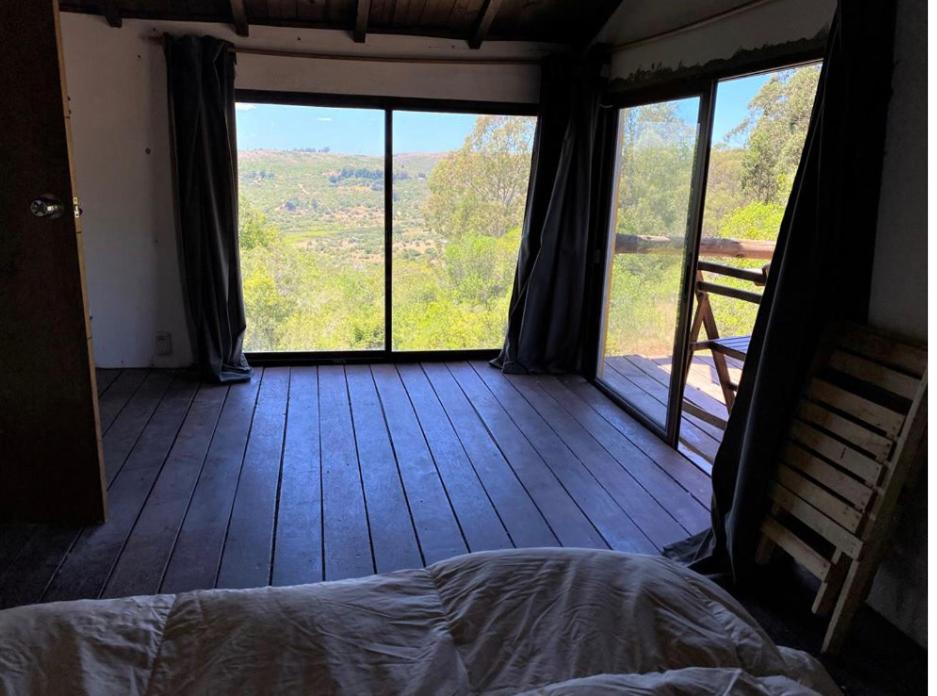 1 dormitorio con 1 cama en una habitación con ventana grande en Peña de Horeb, en Villa Serrana