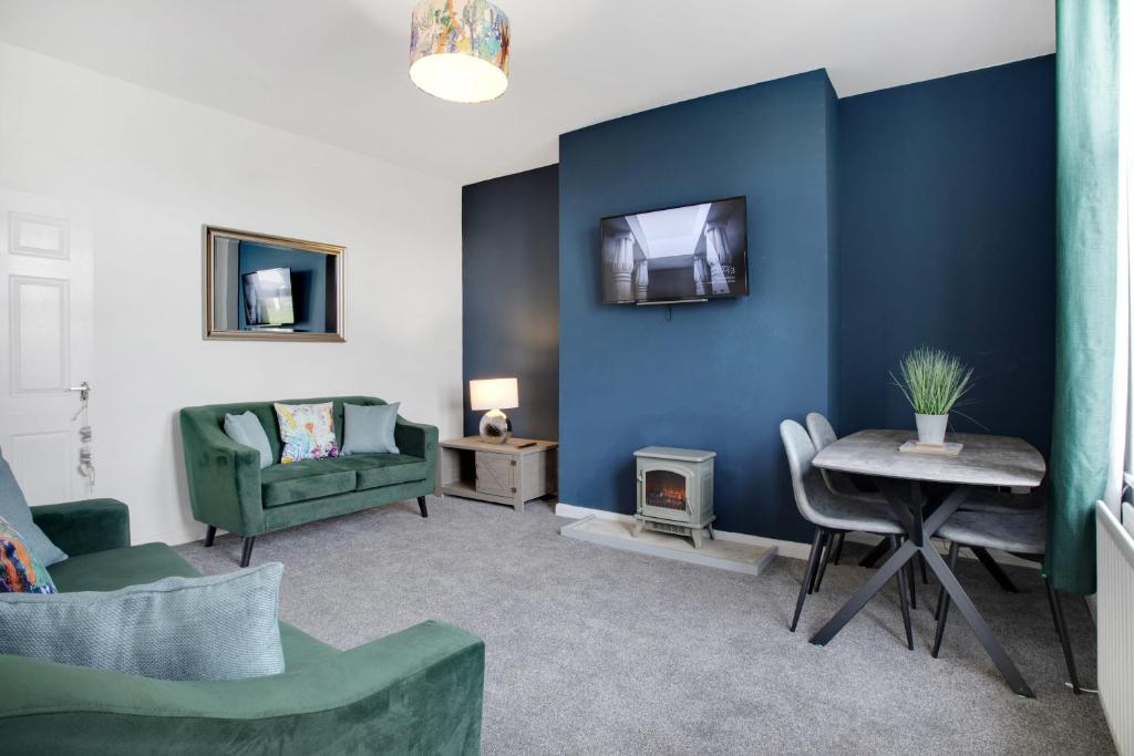 a living room with blue walls and a table and chairs at 2 Bed Cottage with Garden & Stunning Field Views in Durham