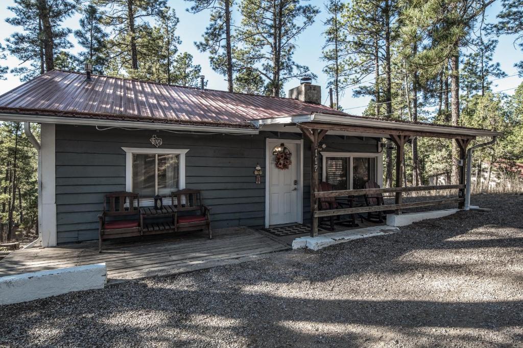 a small house with two benches on a porch at Cuddle Up in Ruidoso