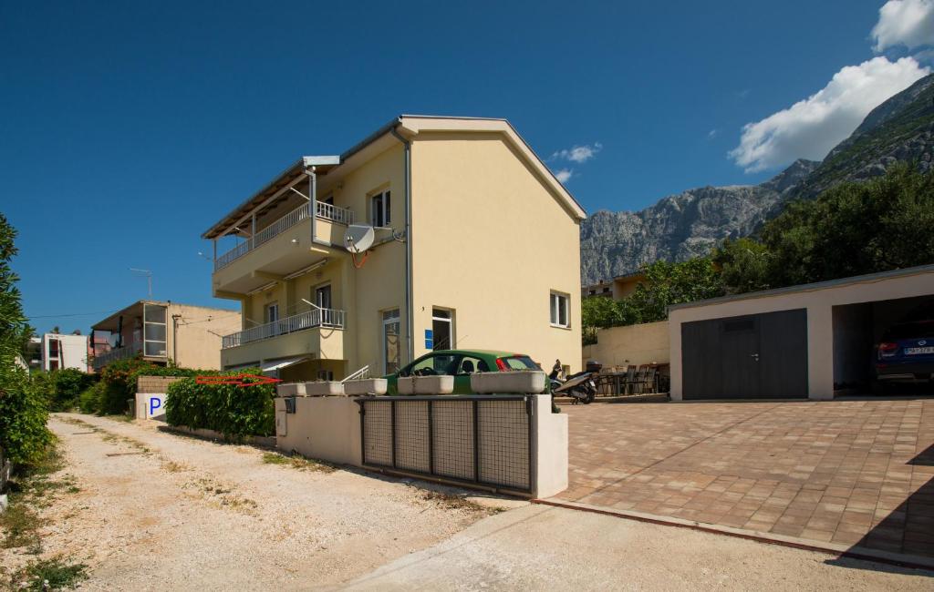 a house with a fence in front of it at Apartman Domenika in Makarska