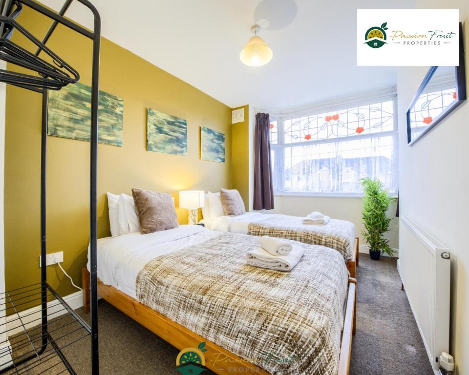 two beds in a room with yellow walls at LOW RATE this season for 5 BR House with 2 Baths- Coventry Near Birmingham By Passionfruit Properties With free Netflix Wi-Fi by A45 - THL in Coventry