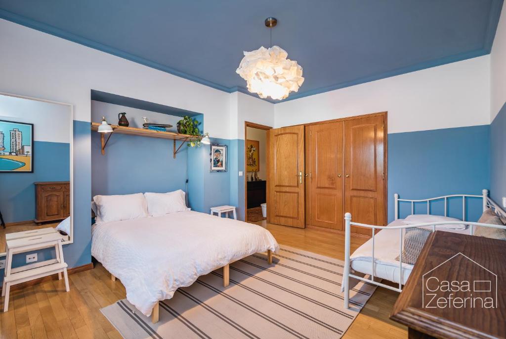 Schlafzimmer mit blauen Wänden, einem Bett und einem Schreibtisch in der Unterkunft Casa Zeferina - Zeferina Family in Leiria