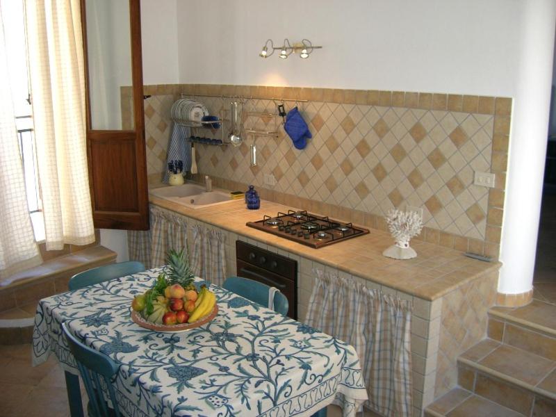 una cocina con una mesa con un bol de fruta. en COLORI DEL MARE FAVIGNANA CENTRO, en Favignana