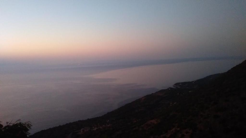 a view of a body of water at sunset at Shiro - traditional stone villa in Agriliá