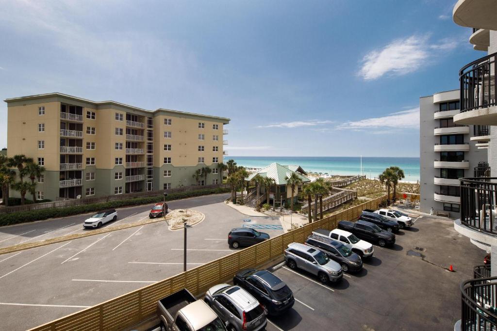 a parking lot with cars parked in front of a building at Nautilus 2411 Gulf View 2 Bedroom 4th Floor Free Beach Service in Fort Walton Beach